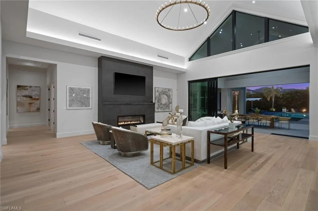 Luxury estate at 115 East Ave in Naples featuring outdoor kitchen, screened lanai, fire pit, and heated saltwater pool within Pine Ridge Estates