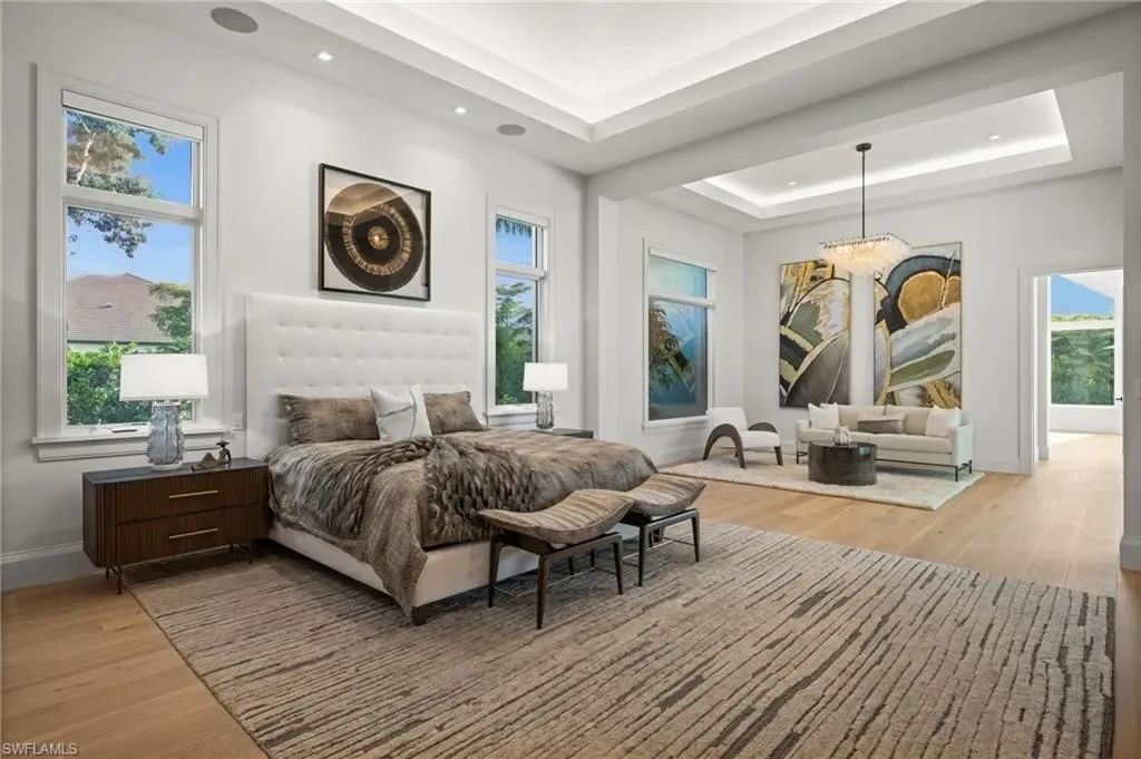 Luxury estate at 115 East Ave in Naples featuring outdoor kitchen, screened lanai, fire pit, and heated saltwater pool within Pine Ridge Estates