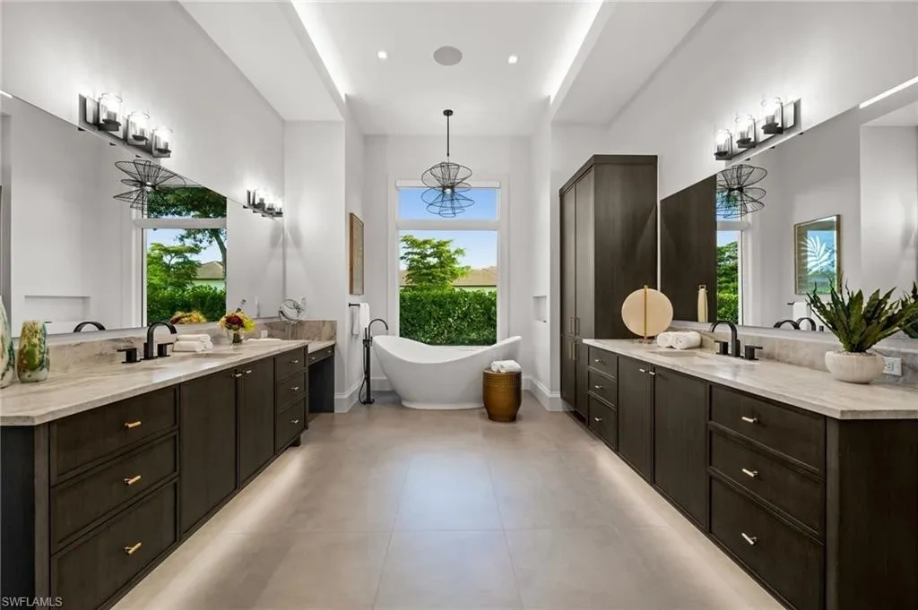 Luxury estate at 115 East Ave in Naples featuring outdoor kitchen, screened lanai, fire pit, and heated saltwater pool within Pine Ridge Estates