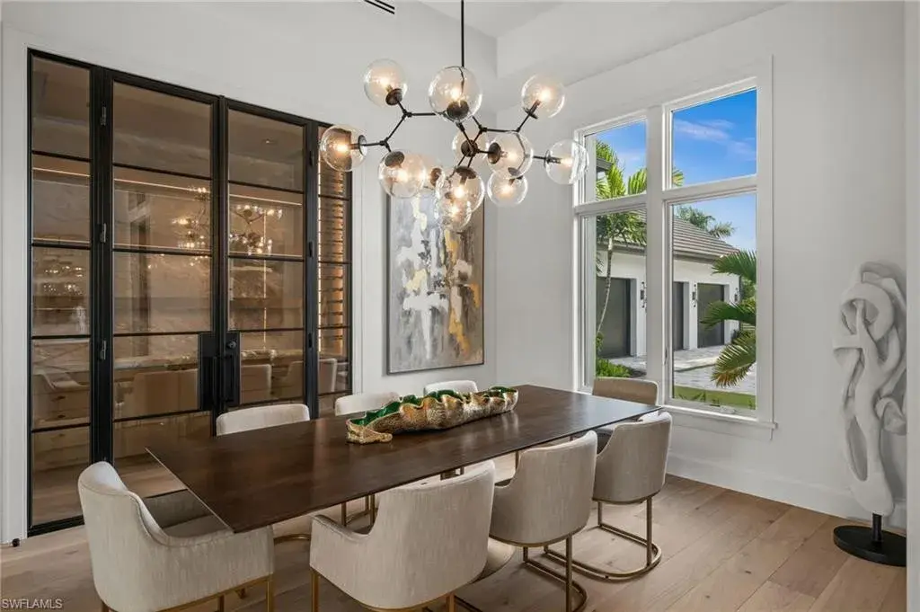 Luxury estate at 115 East Ave in Naples featuring outdoor kitchen, screened lanai, fire pit, and heated saltwater pool within Pine Ridge Estates