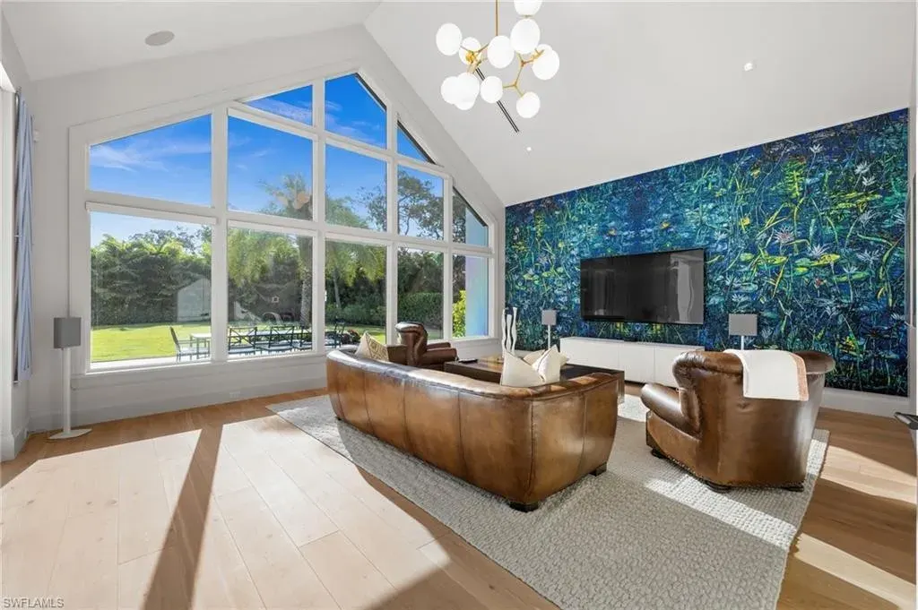 Luxury estate at 115 East Ave in Naples featuring outdoor kitchen, screened lanai, fire pit, and heated saltwater pool within Pine Ridge Estates