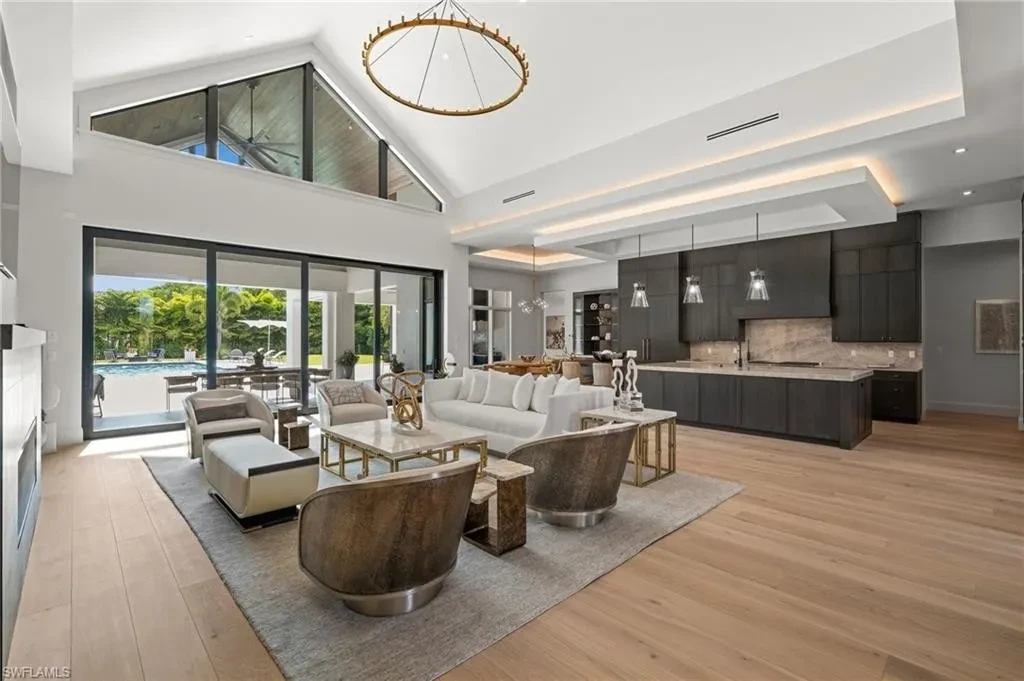 Luxury estate at 115 East Ave in Naples featuring outdoor kitchen, screened lanai, fire pit, and heated saltwater pool within Pine Ridge Estates