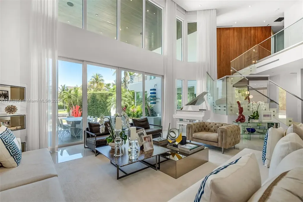 Modern waterfront home at 420 Island Dr in Key Biscayne with lush landscaping and canal view