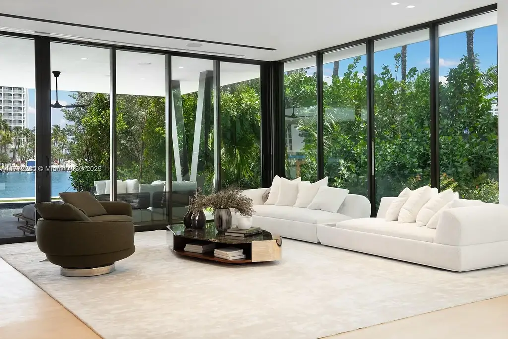 Spacious living room featuring Minotti furnishings, floating staircase, and soaring ceilings in luxury Miami Beach home for sale