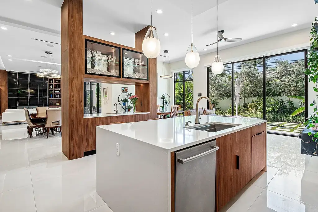 Modern living room inside 450 NE 10th Street featuring soaring ceilings, impact glass, and remote-control fireplace