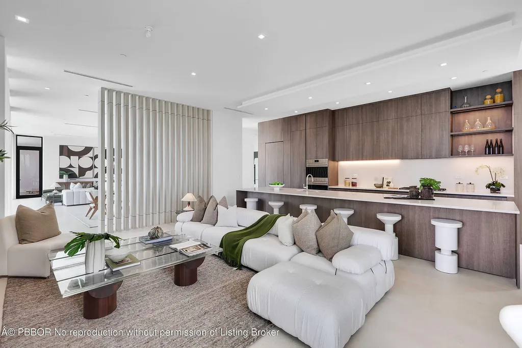 Front view of 10967 Monte Rosa Dr in Palm Beach Gardens, a $9.6 million modern golf estate by architect Max Strang featuring glass facades, terraces, and lake views.