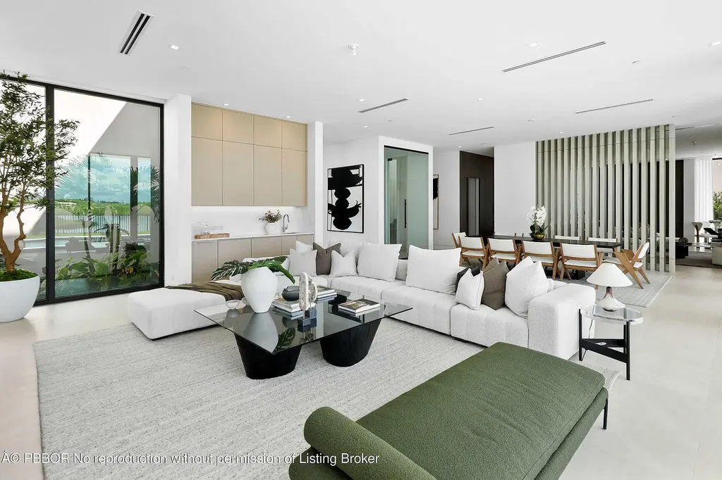 Front view of 10967 Monte Rosa Dr in Palm Beach Gardens, a $9.6 million modern golf estate by architect Max Strang featuring glass facades, terraces, and lake views.