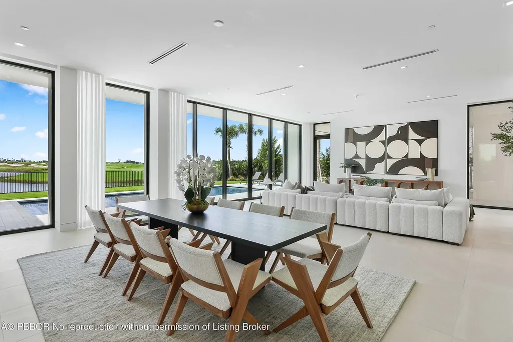Front view of 10967 Monte Rosa Dr in Palm Beach Gardens, a $9.6 million modern golf estate by architect Max Strang featuring glass facades, terraces, and lake views.