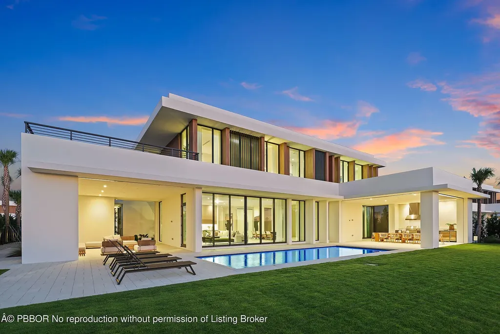 Front view of 10967 Monte Rosa Dr in Palm Beach Gardens, a $9.6 million modern golf estate by architect Max Strang featuring glass facades, terraces, and lake views.