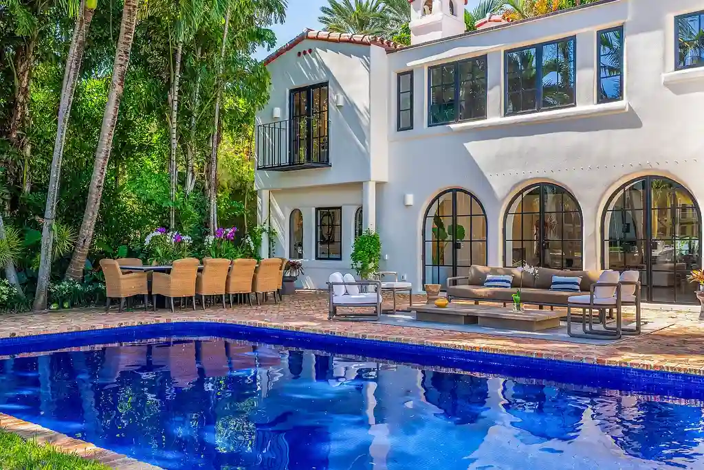 Mediterranean Revival living room with arched windows and coastal interiors at 6065 Pine Tree Dr