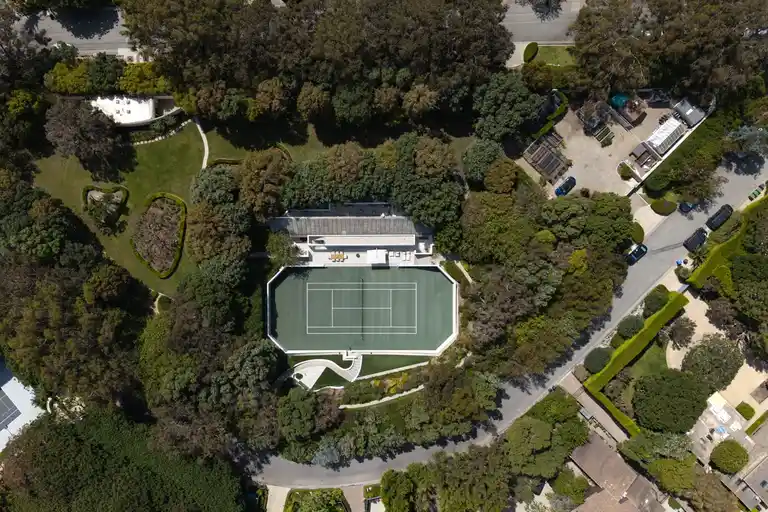 Drone shot of the entire tennis complex and green grounds of the Most Expensive Home in Malibu, The Carson Legacy Estate.