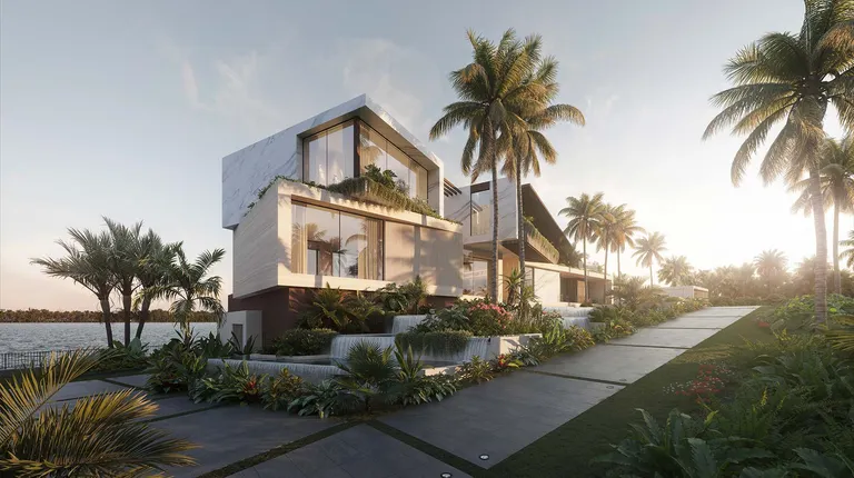 Ocean to Intracoastal mansion in Manalapan, Florida — front exterior with tropical landscaping and waterfront views at sunrise.