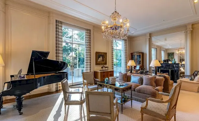 Elegant living room with grand piano and crystal chandelier inside Casa Encantada Bel Air.