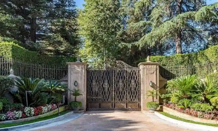 Ornate iron gates and landscaped entrance of Casa Encantada Bel Air Los Angeles.