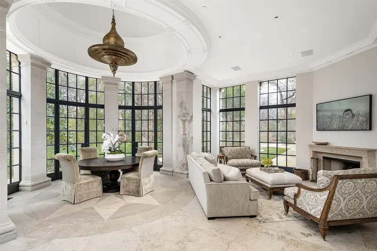 Sunlit conservatory at the most expensive home in Texas with arched windows and limestone columns.