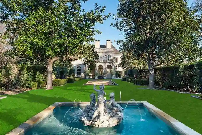 Fountain courtyard at the most expensive home in Texas framed by manicured hedges.