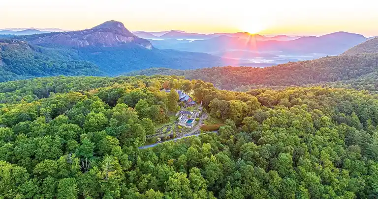 Aerial view of Sagee Manor, the most expensive house in North Carolina, at sunrise over the Blue Ridge Mountains and private 25.92-acre mountaintop estate.