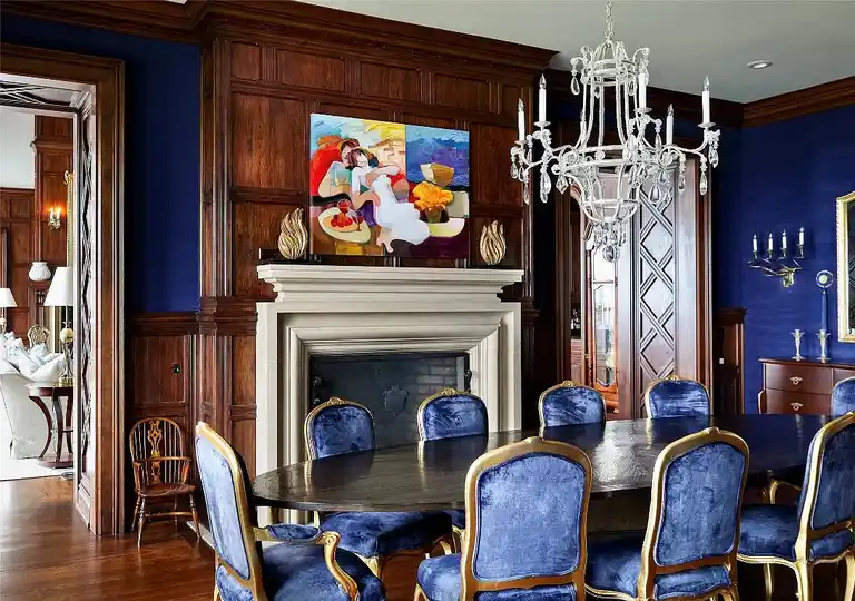 Formal dining room in Sagee Manor, the most expensive house in north carolina, with rich wood paneling, an intricately coffered ceiling, and a long dining table.