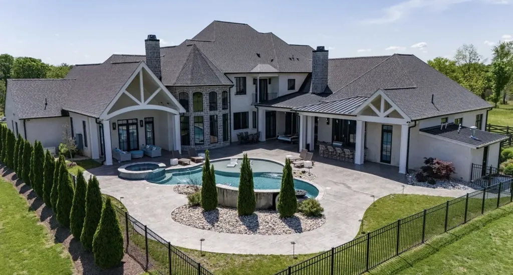 Aerial view of luxury estate in Mount Juliet, Tennessee, showcasing modern architecture, expansive patio, and resort-style pool surrounded by landscaped grounds.