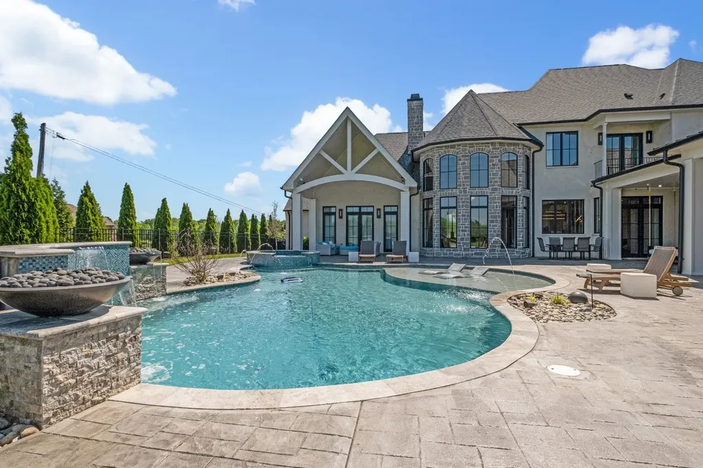 Resort-style swimming pool with spa, water features, and sun loungers at a luxury estate in Mount Juliet, Tennessee.