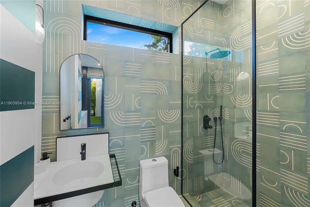 Front exterior of 2053 N Bay Rd Miami Beach modern waterfront estate with sleek architecture and tropical landscaping