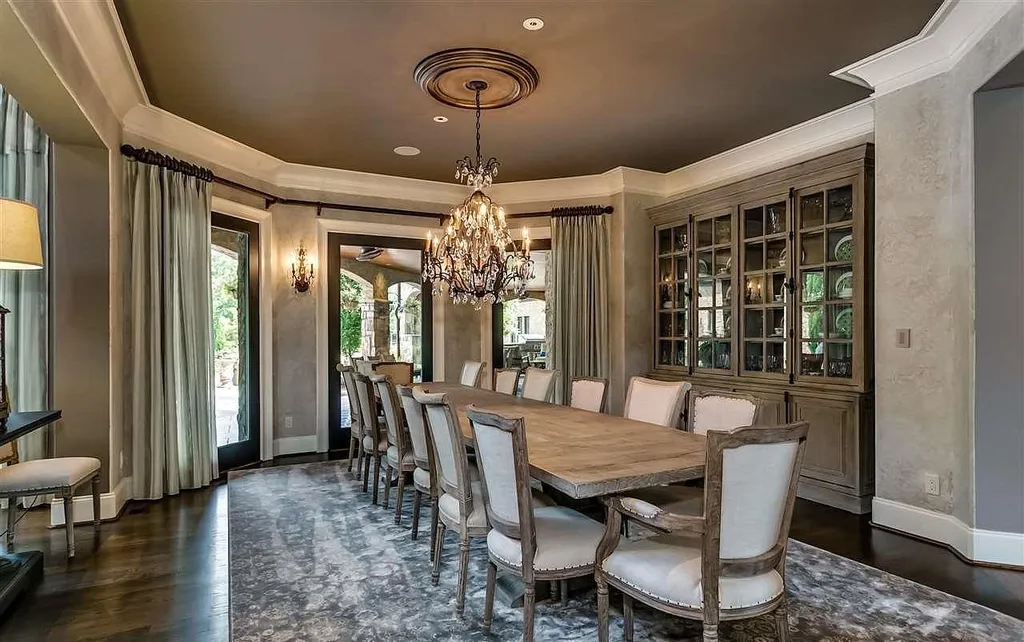 Elegant dining room at 2470 Cahaba Valley Rd, Indian Springs, Alabama, featuring a grand chandelier, custom cabinetry, and French-inspired design, highlighted in Luxury Houses Magazine.