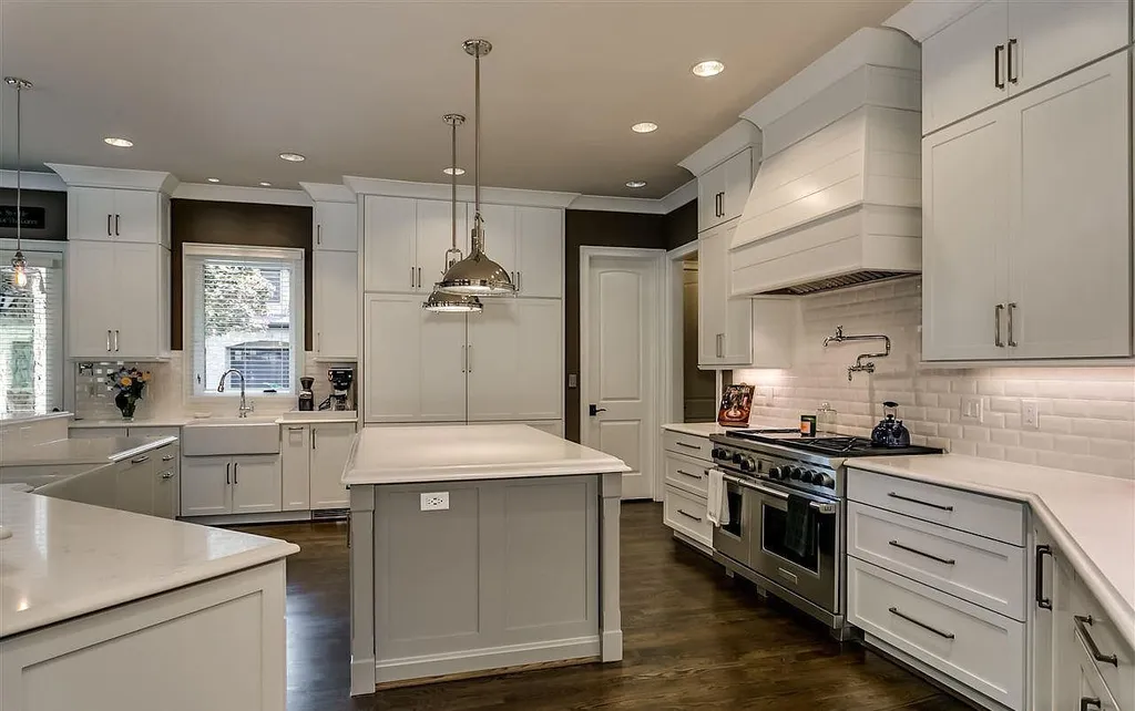 Luxury kitchen at 2470 Cahaba Valley Rd, Indian Springs, Alabama, featuring white shaker cabinets, marble countertops, stainless steel appliances, and pendant lighting, as seen in Luxury Houses Magazine.