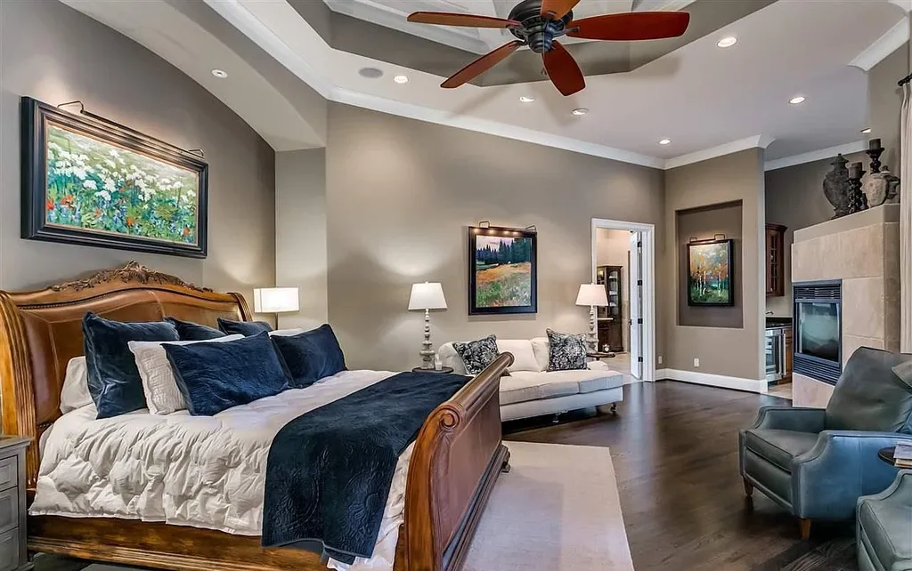 Elegant master bedroom at 2470 Cahaba Valley Rd, Indian Springs, Alabama, featuring a fireplace, hardwood floors, and fine art décor, captured for Luxury Houses Magazine.