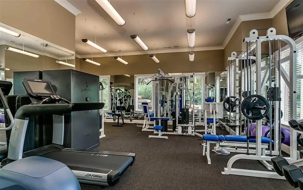 Elegant master bedroom at 2470 Cahaba Valley Rd, Indian Springs, Alabama, featuring a fireplace, hardwood floors, and fine art décor, captured for Luxury Houses Magazine.