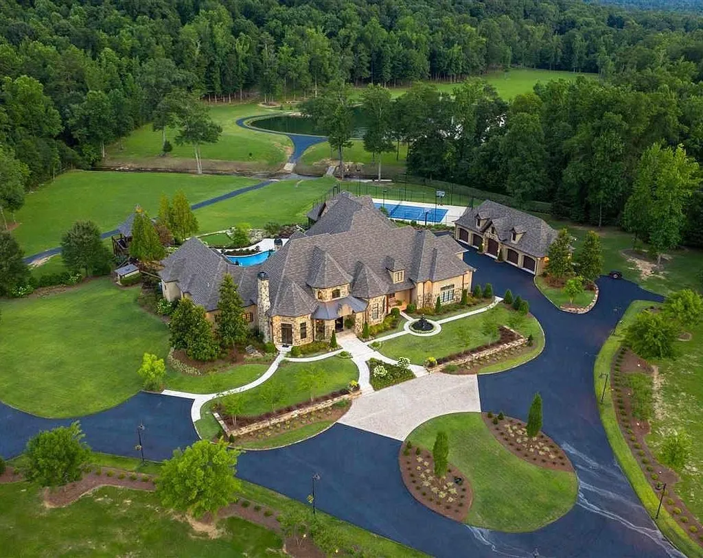 Aerial view of the luxury estate at 2470 Cahaba Valley Rd, Indian Springs, Alabama, showcasing its expansive 41-acre grounds, tennis court, pond, and elegant French-inspired architecture surrounded by lush greenery, as featured in Luxury Houses Magazine.