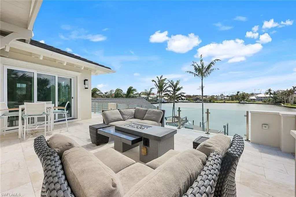 Bayfront luxury residence at 350 Spring Line DR in Naples featuring pool, spa, travertine lanai, and waterfront deck with boat lift.