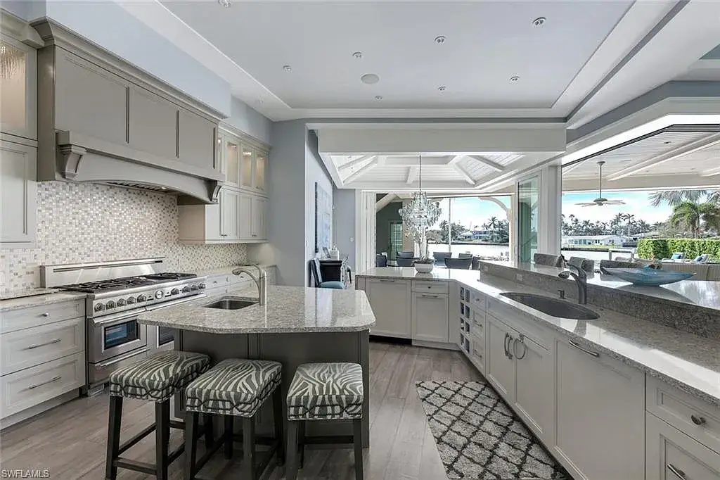 Bayfront luxury residence at 350 Spring Line DR in Naples featuring pool, spa, travertine lanai, and waterfront deck with boat lift.