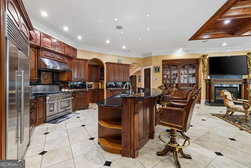 Close-up view of the professional-grade stainless steel range and ventilation hood in the gourmet kitchen, surrounded by dark mahogany cabinetry and a checkered marble floor.
