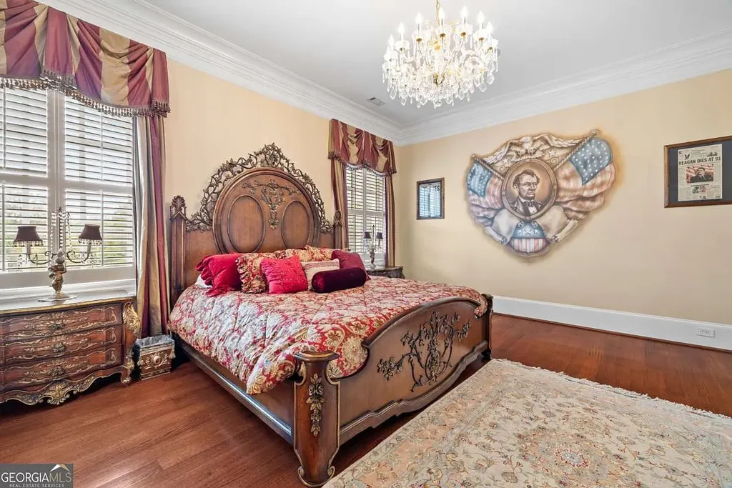A uniquely themed bedroom with a classic wooden bed, crystal chandelier, and a large wall mural featuring Abraham Lincoln and the American flag.