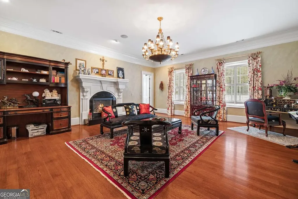 A secondary living room or study in the Atlanta White House featuring a decorative fireplace, built-in shelving, rich hardwood floors, and classical Chinese furniture accents.