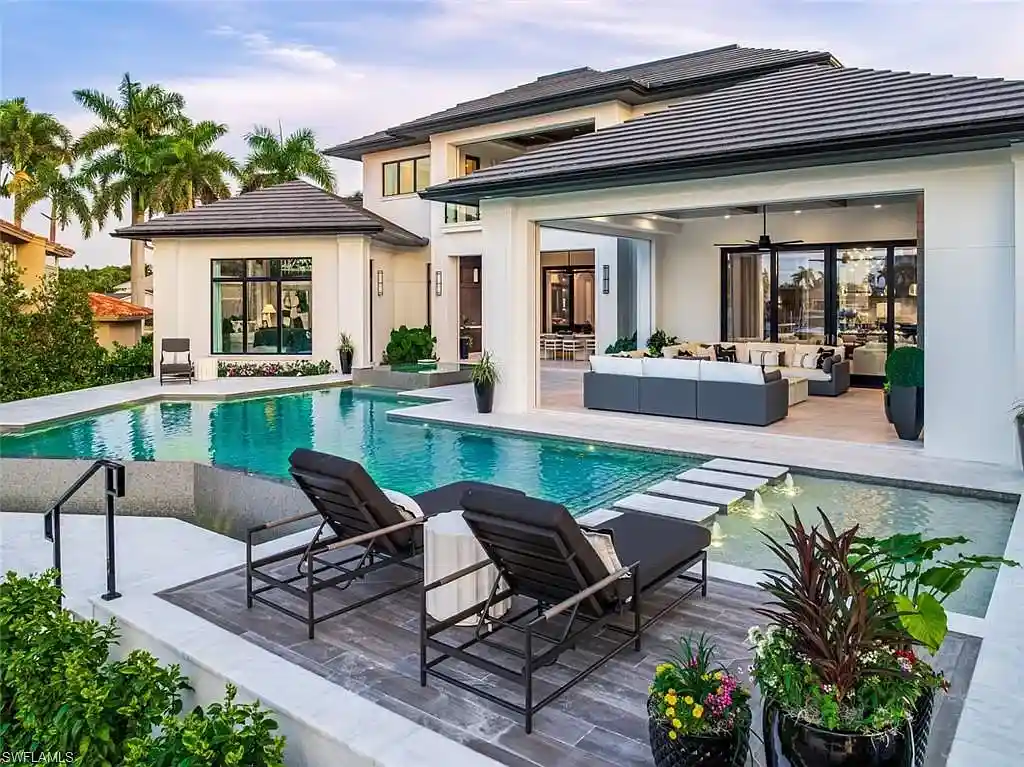 405 NEAPOLITAN WAY Naples FL luxury waterfront home featuring 5 bedrooms, 7 bathrooms, resort-style pool, outdoor kitchen, and panoramic bay views.