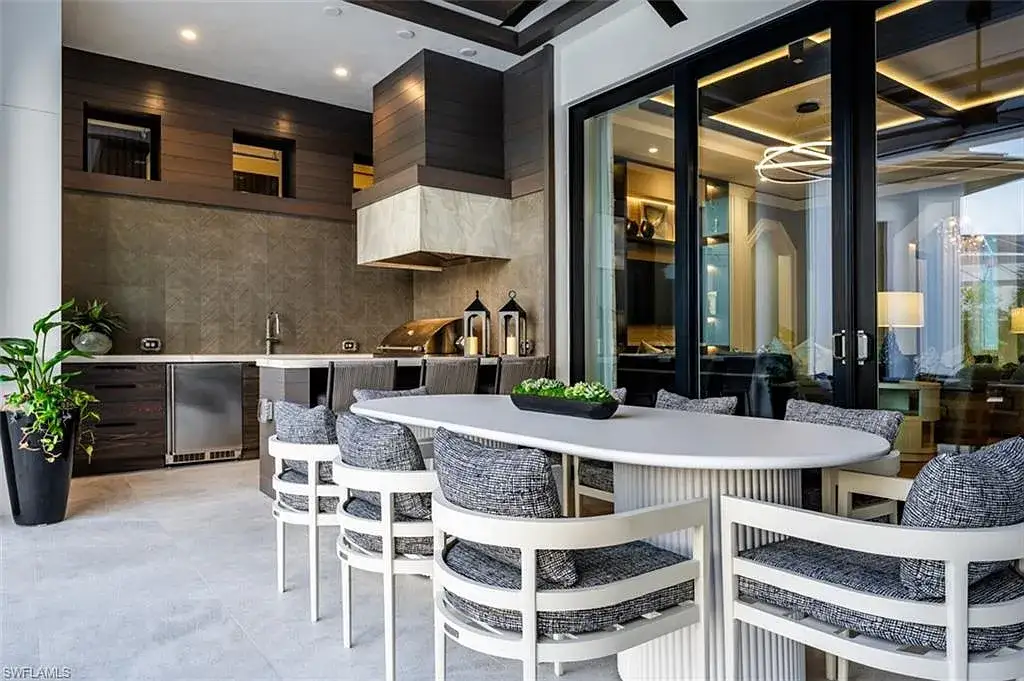 405 NEAPOLITAN WAY Naples FL luxury waterfront home featuring 5 bedrooms, 7 bathrooms, resort-style pool, outdoor kitchen, and panoramic bay views.