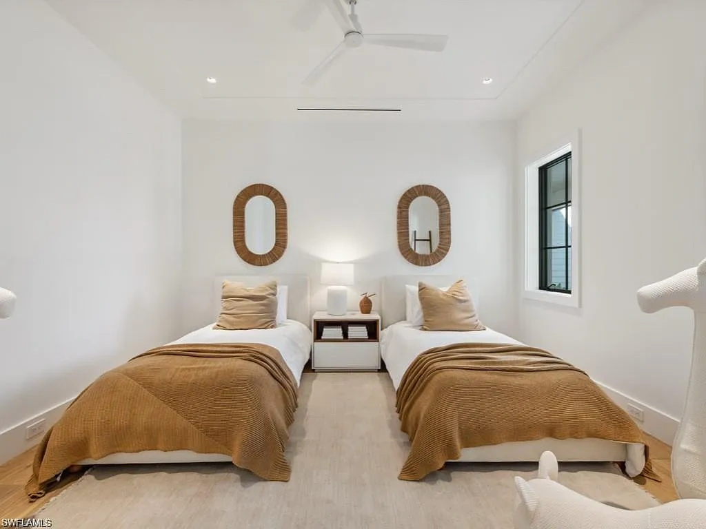 Front exterior view of 424 Spinnaker DR in Naples, showing gated courtyard, lime-washed brick, and lush landscaping.