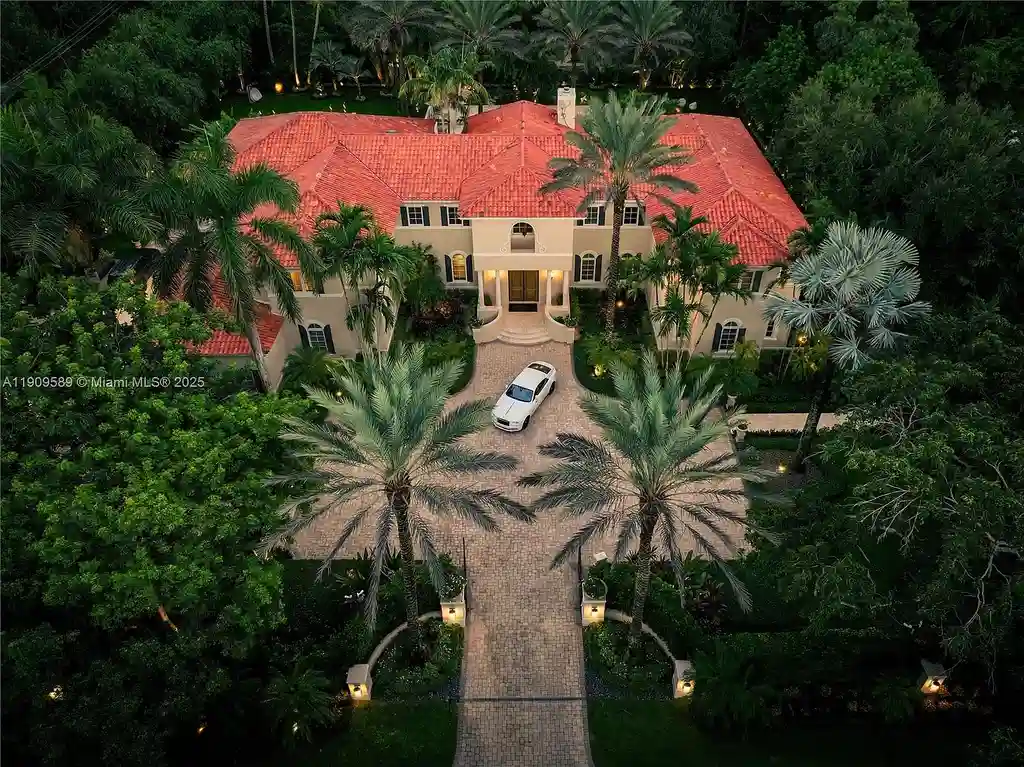 A Spectacular $18.5 Million Waterfront Estate Offering Elevated Luxury Living in Coral Gables 5 Front view of 5250 Snapper Creek Rd in Coral Gables showing the gated entrance, lush landscaping, and Mediterranean-inspired architecture.
