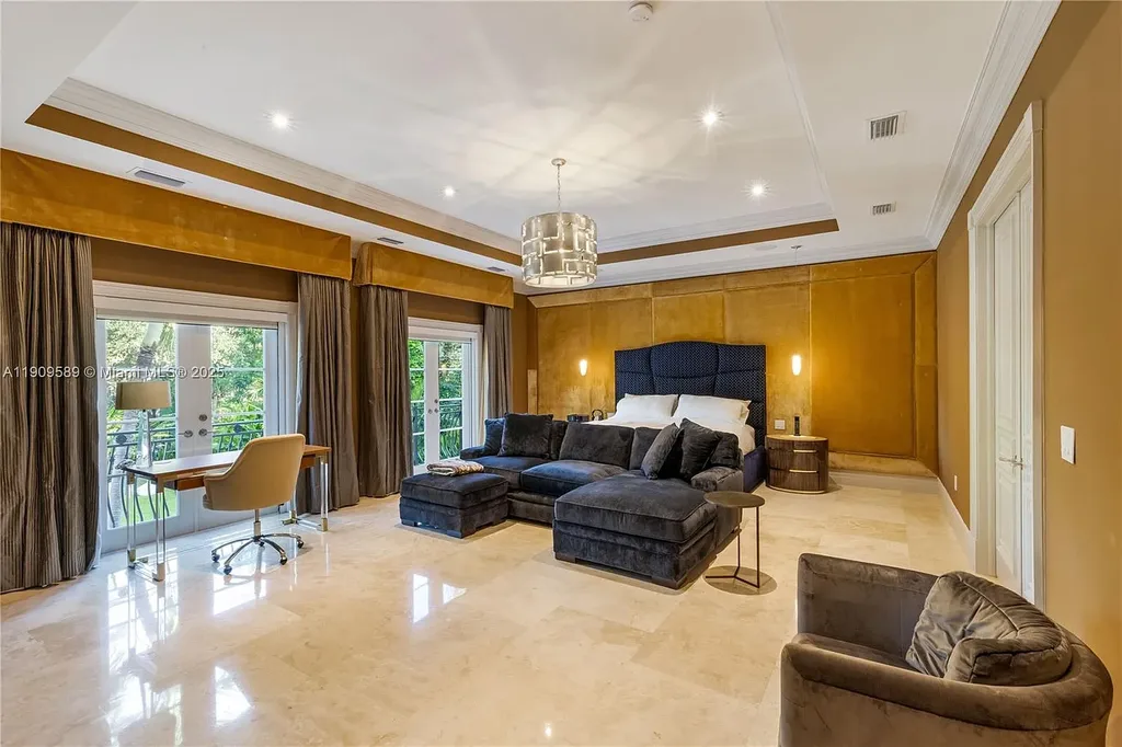 A Spectacular $18.5 Million Waterfront Estate Offering Elevated Luxury Living in Coral Gables 13 Front view of 5250 Snapper Creek Rd in Coral Gables showing the gated entrance, lush landscaping, and Mediterranean-inspired architecture.