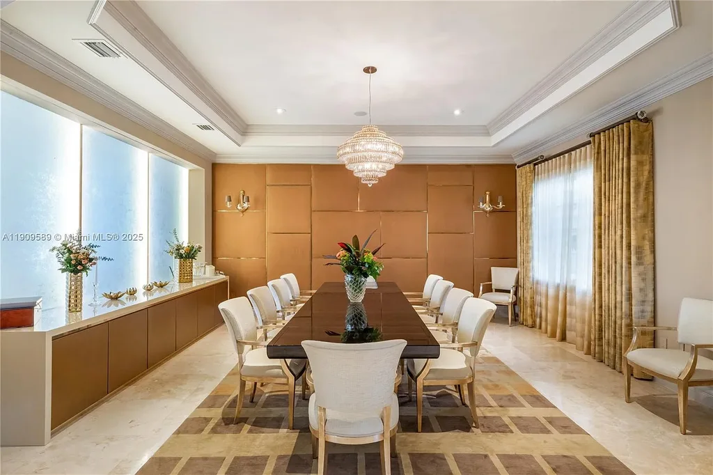 A Spectacular $18.5 Million Waterfront Estate Offering Elevated Luxury Living in Coral Gables 12 Front view of 5250 Snapper Creek Rd in Coral Gables showing the gated entrance, lush landscaping, and Mediterranean-inspired architecture.