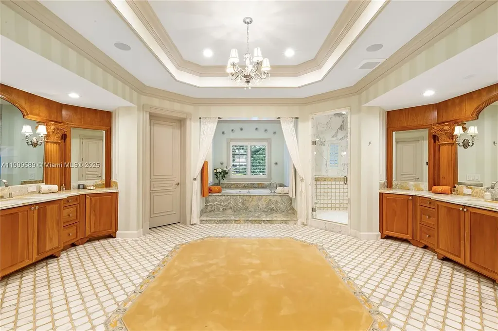 A Spectacular $18.5 Million Waterfront Estate Offering Elevated Luxury Living in Coral Gables 15 Front view of 5250 Snapper Creek Rd in Coral Gables showing the gated entrance, lush landscaping, and Mediterranean-inspired architecture.