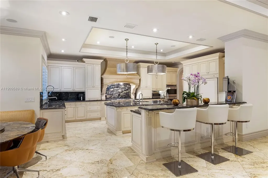 A Spectacular $18.5 Million Waterfront Estate Offering Elevated Luxury Living in Coral Gables 10 Front view of 5250 Snapper Creek Rd in Coral Gables showing the gated entrance, lush landscaping, and Mediterranean-inspired architecture.