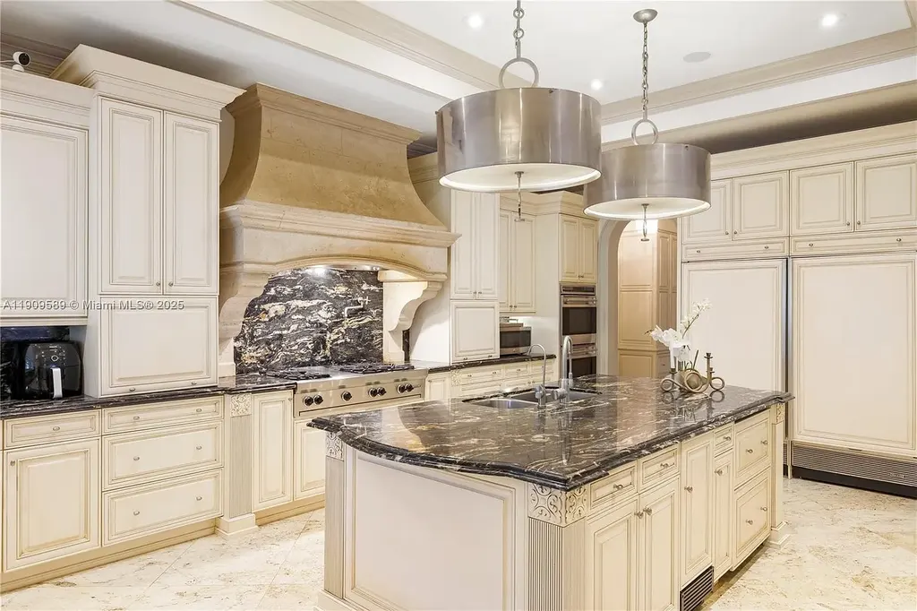 A Spectacular $18.5 Million Waterfront Estate Offering Elevated Luxury Living in Coral Gables 11 Front view of 5250 Snapper Creek Rd in Coral Gables showing the gated entrance, lush landscaping, and Mediterranean-inspired architecture.