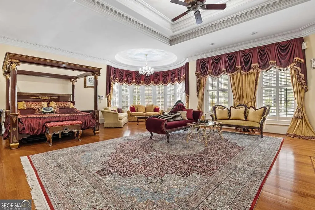The luxurious Master Suite inside the Atlanta White House, featuring a four-poster canopy bed, high tray ceilings, hardwood floors, and a dedicated bay window seating area.