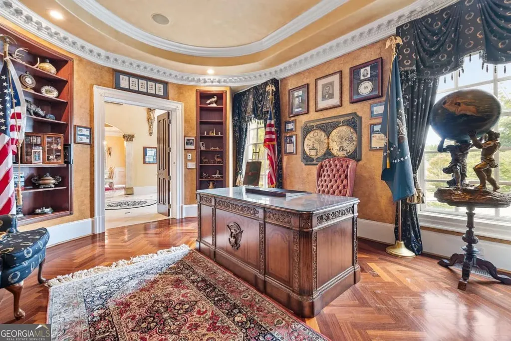 Interior view of the custom Oval Office desk and herringbone wood floor, showing the doorway connecting to the main grand foyer of the Atlanta White House.