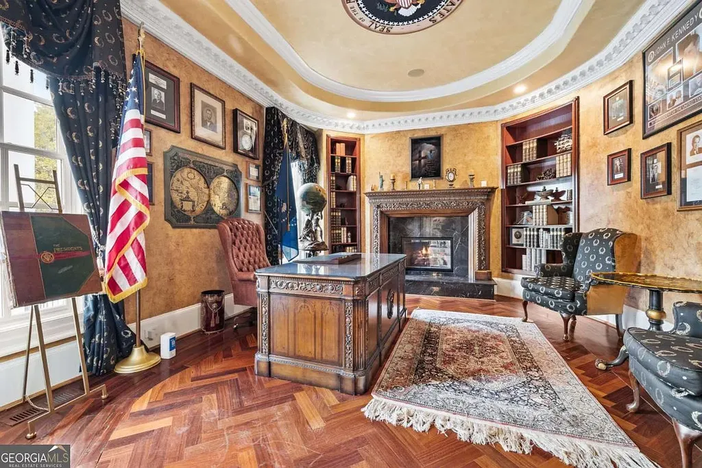 Interior photo of the private Oval Office in the Atlanta White House, featuring the Presidential Seal ceiling, antique desk, fireplace, and herringbone wood floor.