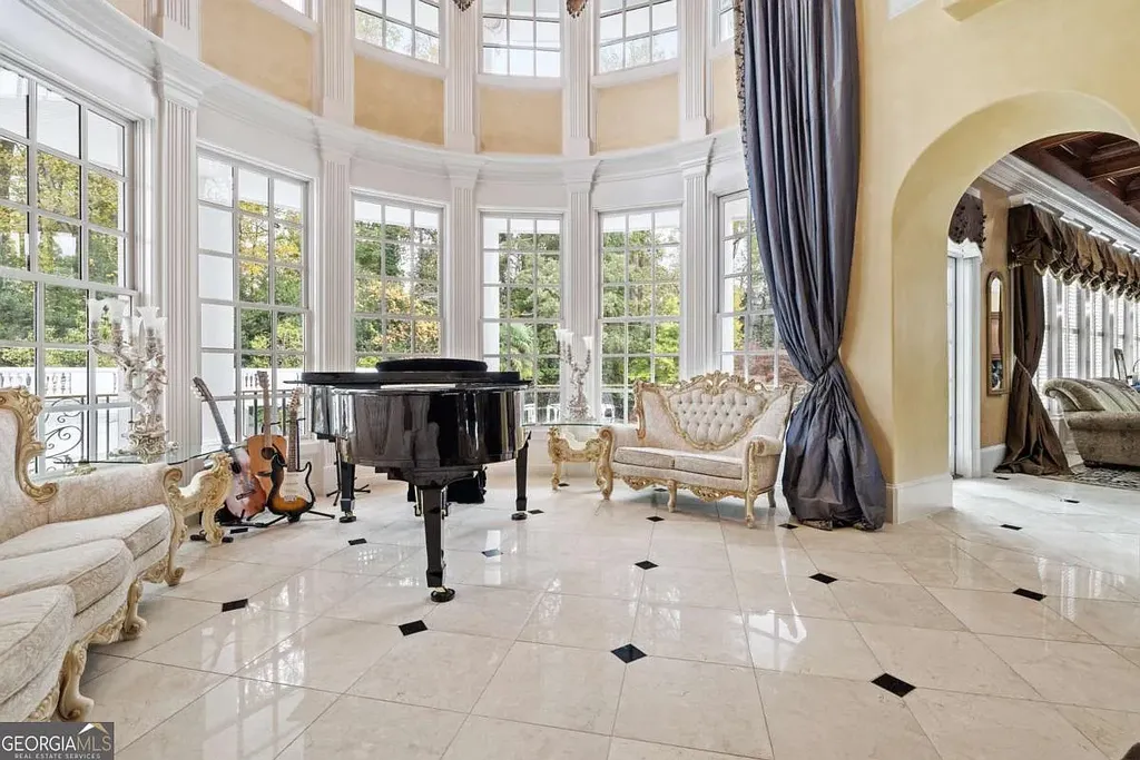 The two-story piano salon inside the Atlanta White House, featuring expansive curved windows, marble floors, a grand piano, and gilded furniture.