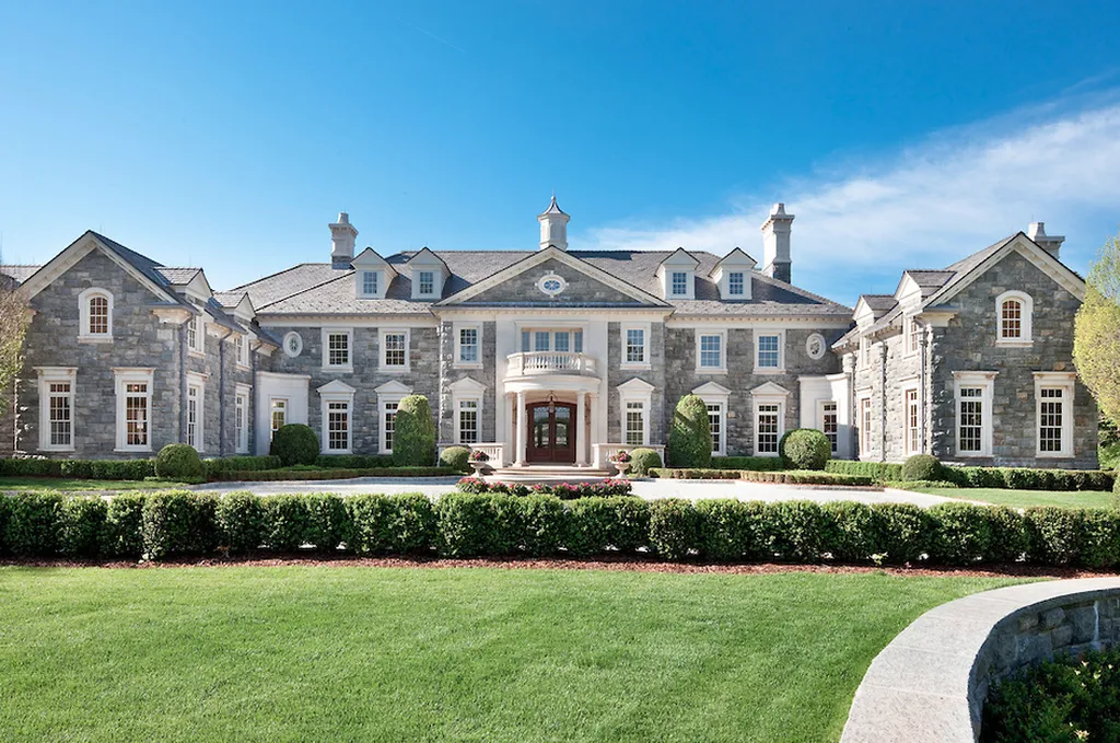Step Inside One of America’s Most Extraordinary Modern Estates in Alpine 2 Front elevation of the grand luxury mansion at 1 Frick Drive in Alpine New Jersey with stone façade manicured landscaping and symmetrical architectural design.