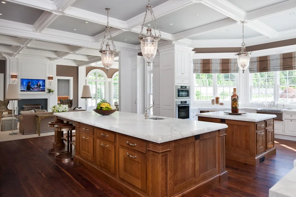 Step Inside One of America’s Most Extraordinary Modern Estates in Alpine 7 Luxury gourmet kitchen at 1 Frick Drive in Alpine New Jersey featuring marble countertops double islands custom wood cabinetry and elegant pendant lighting.
